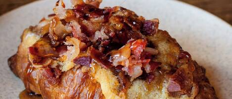 Un plato de desayuno con tocino y jarabe.