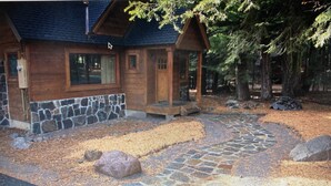 A wooden cabin with a stone foundation, a stone pathway, and a forested backdrop. - Classic Family Tahoe Cabin - West Shore Bliss! (Tahoma)