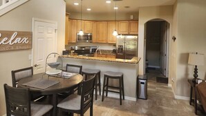 Una cocina moderna con armarios de madera, electrodomésticos de acero inoxidable y encimera de granito.