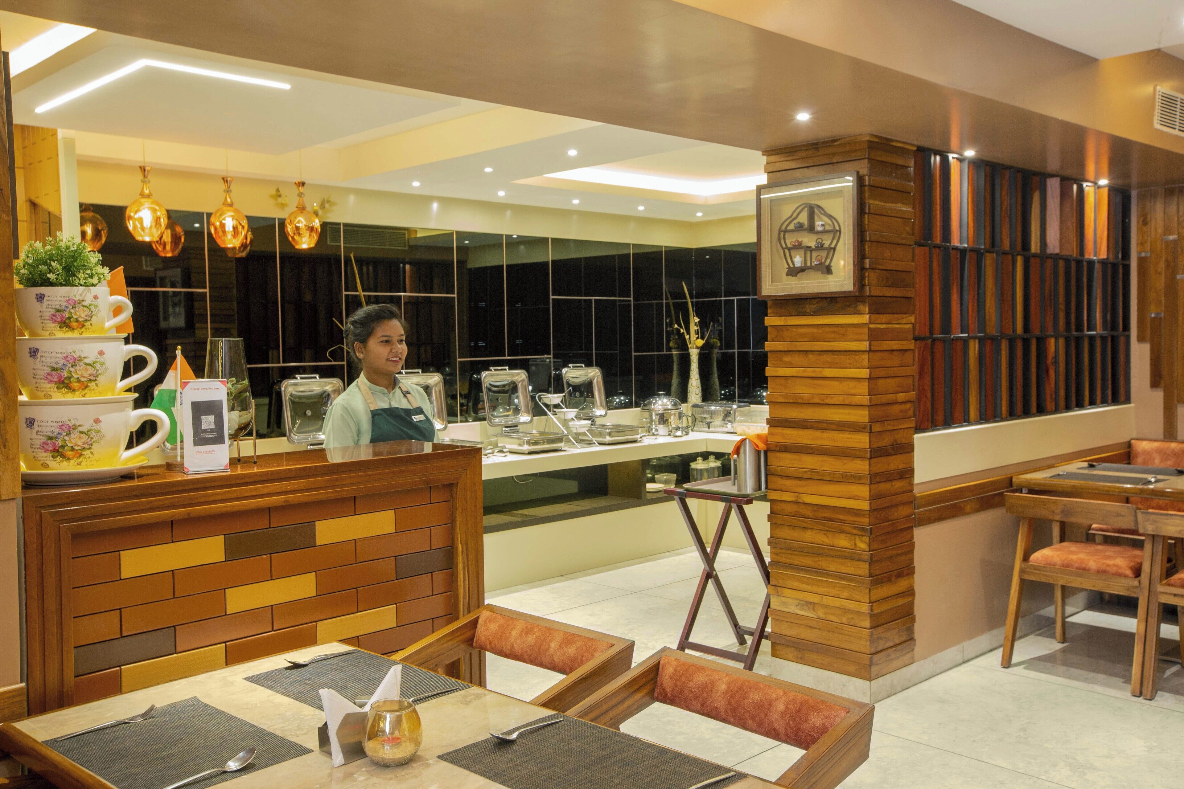 A restaurant with a wooden counter, seating area, and a modern interior design.