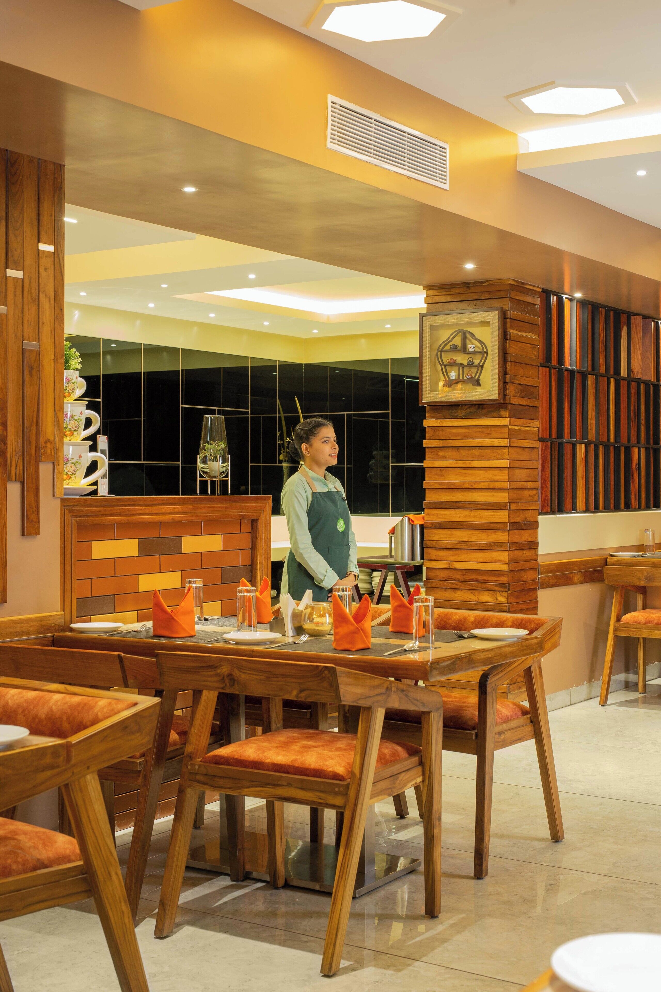 Un restaurant avec des meubles en bois et une serveuse.