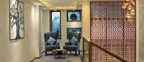 A modern interior with two armchairs, a coffee table, and decorative wall art.