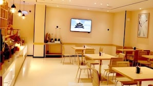 A modern restaurant with a counter, tables, and chairs. - City Comfort Inn Huangshi Bei Station (Huangshi)
