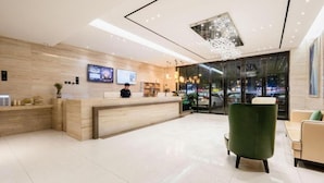 A modern hotel lobby with a reception desk, seating area, and a large window offering a view of the cityscape. - City Comfort Inn Huangshi Bei Station (Huangshi)
