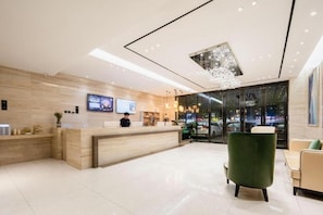 A modern hotel lobby with a reception desk, seating area, and a large window offering a view of the cityscape. - City Comfort Inn Huangshi Bei Station (Huangshi)