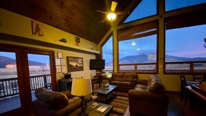 A cozy living room with a large window overlooking a mountainous landscape. - Beautiful Views! Home near Grand Canyon, Flagstaff (Flagstaff)