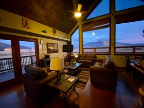 A cozy living room with a large window overlooking a mountainous landscape.