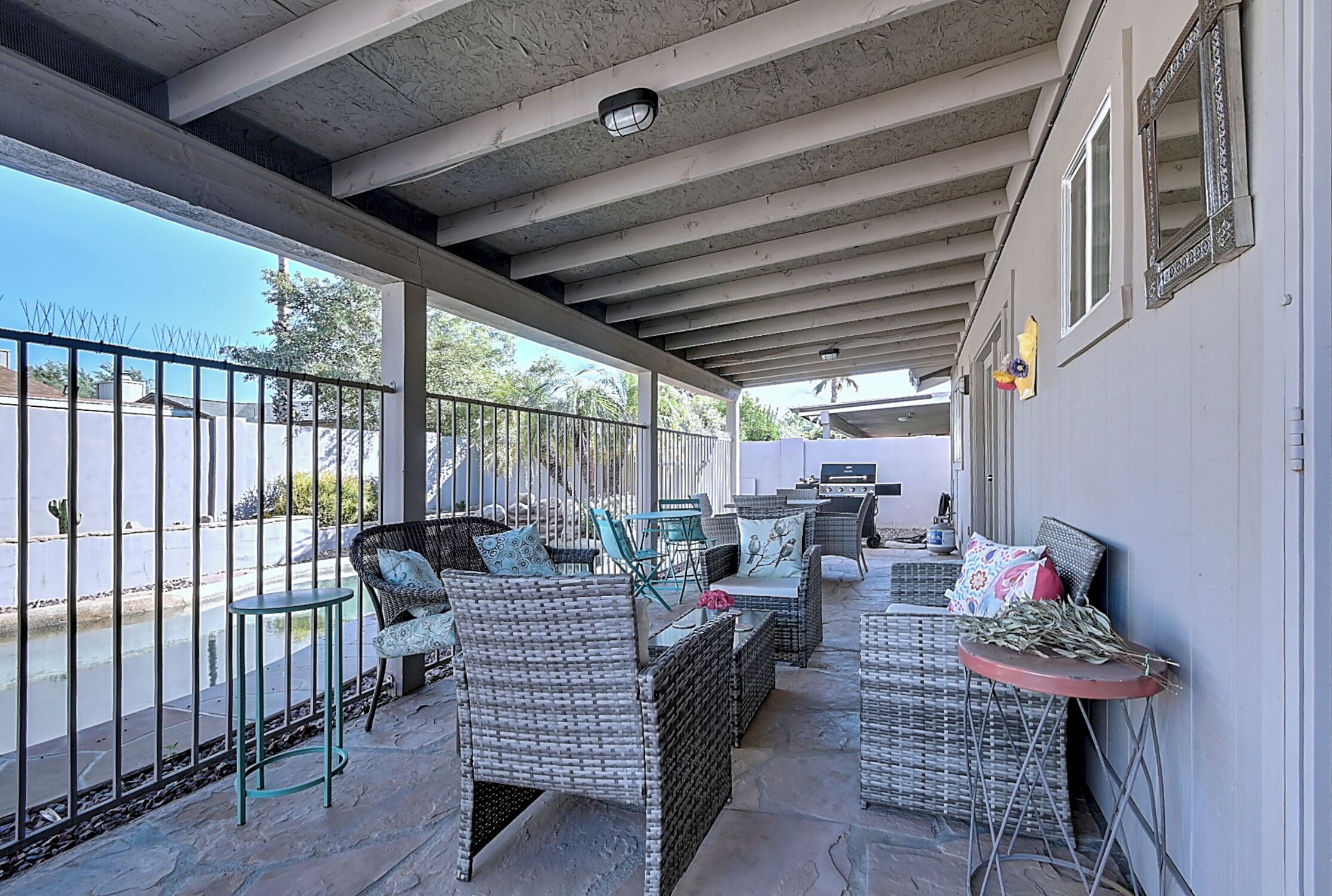 An outdoor patio with wicker furniture, a small table, and a view of the street.