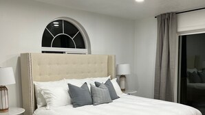 Una camera da letto con un letto grande, due comodini, una finestra con vista e un tappeto decorato.