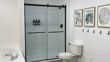 Bañera con ducha, bañera de hidromasaje, jabón, papel higiénico