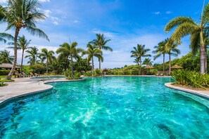 A clear blue pool surrounded by palm trees and lounge chairs. - 🏖️Kulalani 2BR Townhome | Beach Club Access + Pools (Kamuela)