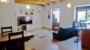A spacious living area with a television, seating, and a window. - Vacation home in traditional style in a very quiet location (Starigrad Paklenica)