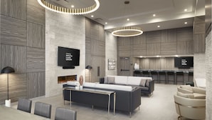 A modern living room with a glass-top table, sofas, and a fireplace. - Level Seattle Downtown - South Lake Union (Seattle)