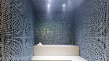 Bathroom features a clean white bathtub and a blue mosaic tile wall.