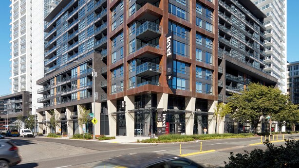 A modern multi-story building with a unique angular design, featuring a mix of glass and metal materials. - Level Seattle Downtown - South Lake Union (Seattle)