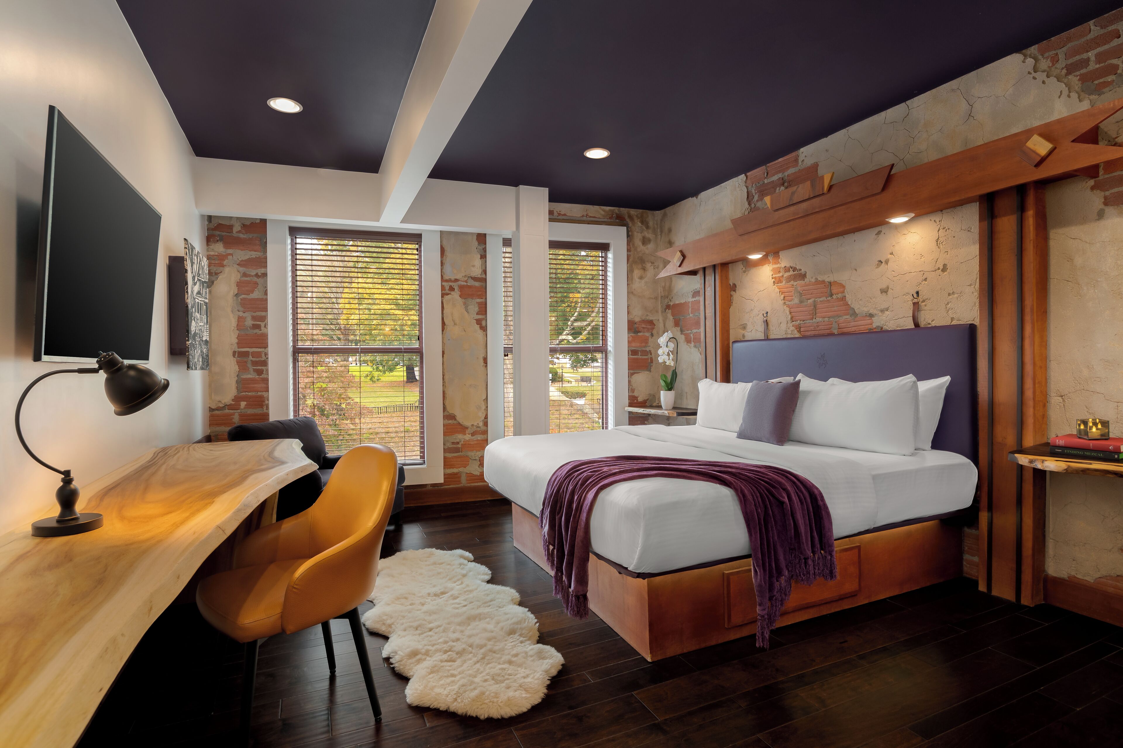 Een moderne slaapkamer met een groot bed, een bureau en een stoel.