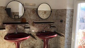 A bathroom with two sinks, a mirror, and a red light fixture. - A Casa Piatatella (Aregno)