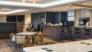 A modern hotel lobby with a bar area, seating arrangements, and a counter with coffee machines. - Courtyard by Marriott Santa Cruz (Santa Cruz)