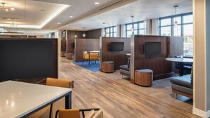A modern office space with cubicles, seating areas, and a large TV screen. - Courtyard by Marriott Santa Cruz (Santa Cruz)