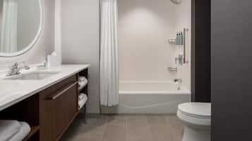 A modern bathroom with a sink, mirror, shower, and toilet.