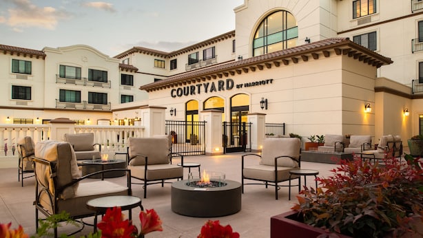 A Courtyard by Marriott hotel with outdoor seating, a fire pit, and potted plants. - Courtyard by Marriott Santa Cruz (Santa Cruz)