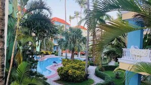 Une piscine entourée de palmiers et un bâtiment avec un toit rouge.