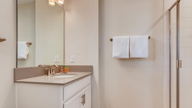 Une salle de bain équipée d’un lavabo, d’un miroir et d’un porte-serviettes.