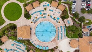 An aerial view of a resort with a central swimming pool, multiple lounge areas, and a parking lot. - 1556 PD - Poolside Bliss: Enchanted 4BR Townhome (Four Corners)