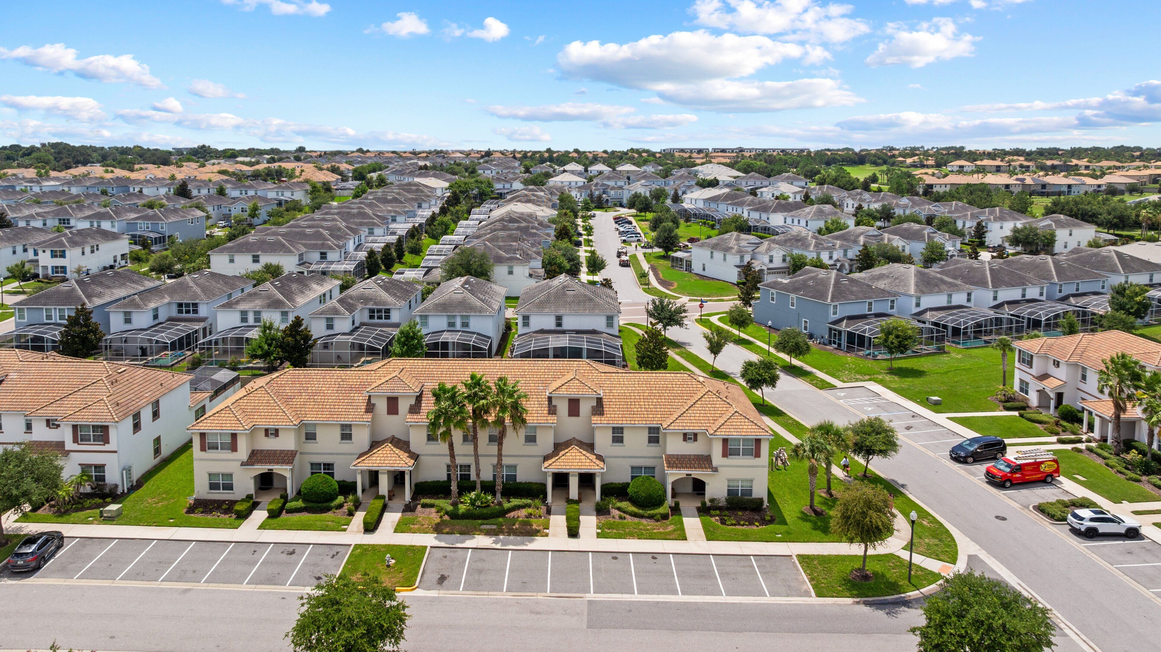 A residential area with multiple two-story houses, a parking lot, and a road.