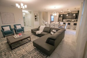 Relax in this stylish living room with a sofa, armchairs, and coffee table.