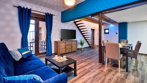 A modern living room with a sofa, coffee table, TV, and a staircase leading to a dining area. - Awesome home in Beretinec with sauna (Beretinec)