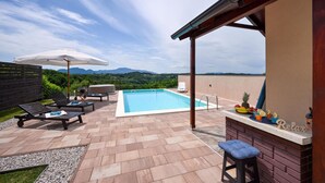 A rooftop pool area with a view of mountains, outdoor seating, and a bar. - Awesome home in Beretinec with sauna (Beretinec)