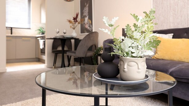 A modern living room with a glass coffee table, a sofa, and a dining area in the background. - Splendid Apartment near City Centre (Edinburgh)