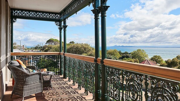 A balcony with wicker furniture and a view of the sea. - Portarlington Grand Hotel (Portarlington)