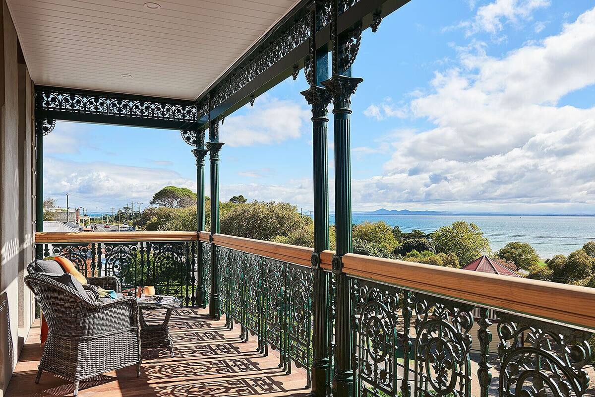 A balcony with wicker furniture and a view of the sea.