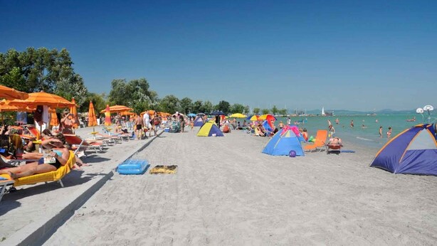 A beach with tents, umbrellas, and people sunbathing. - Holiday apartment with wifi and parking (Balatonboglár)