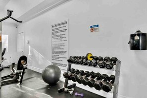 Een sportschool met trainingsapparatuur, een grote fitnessbal en een dumbbellrek.