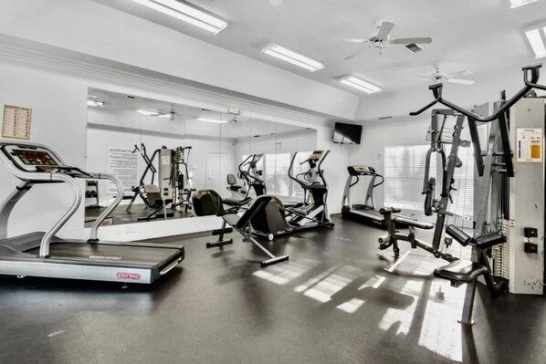 Een sportschool met loopbanden, elliptische trainers en gewichten.