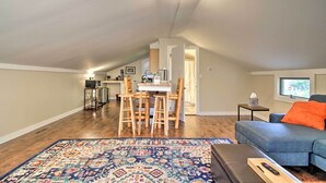 A cozy loft apartment with a dining area, kitchen, and a living room with a blue sofa and a colorful rug. - Idyllic Wallingford Retreat - Near Skiing & Hiking (Wallingford)