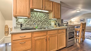 A kitchen with wooden cabinets, a tiled backsplash, a stainless steel sink, and a built-in oven. - Idyllic Wallingford Retreat - Near Skiing & Hiking (Wallingford)