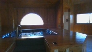 A wooden interior with a large arched window, a sink, and a small window to the right. - Cedar Village Condo A5, Beech Mountain, NC (Beech Mountain)