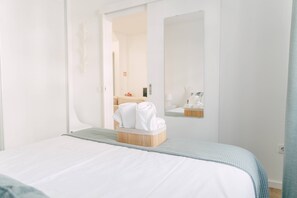 Ein Hotelzimmer mit einem Bett, einem Holznachttisch und einem Spiegel an der Wand.
