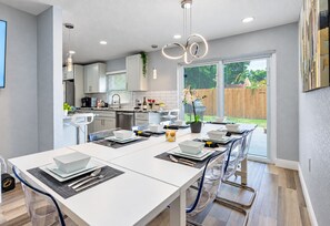A modern kitchen with a dining area set up for a meal. - Heated Pool, Sleeps 10, 15 Min to Beach | PS5 Game Nights, Largo (Largo)