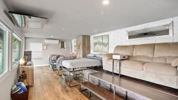 Um interior moderno com um sofá, uma cama e uma mesa de jantar.