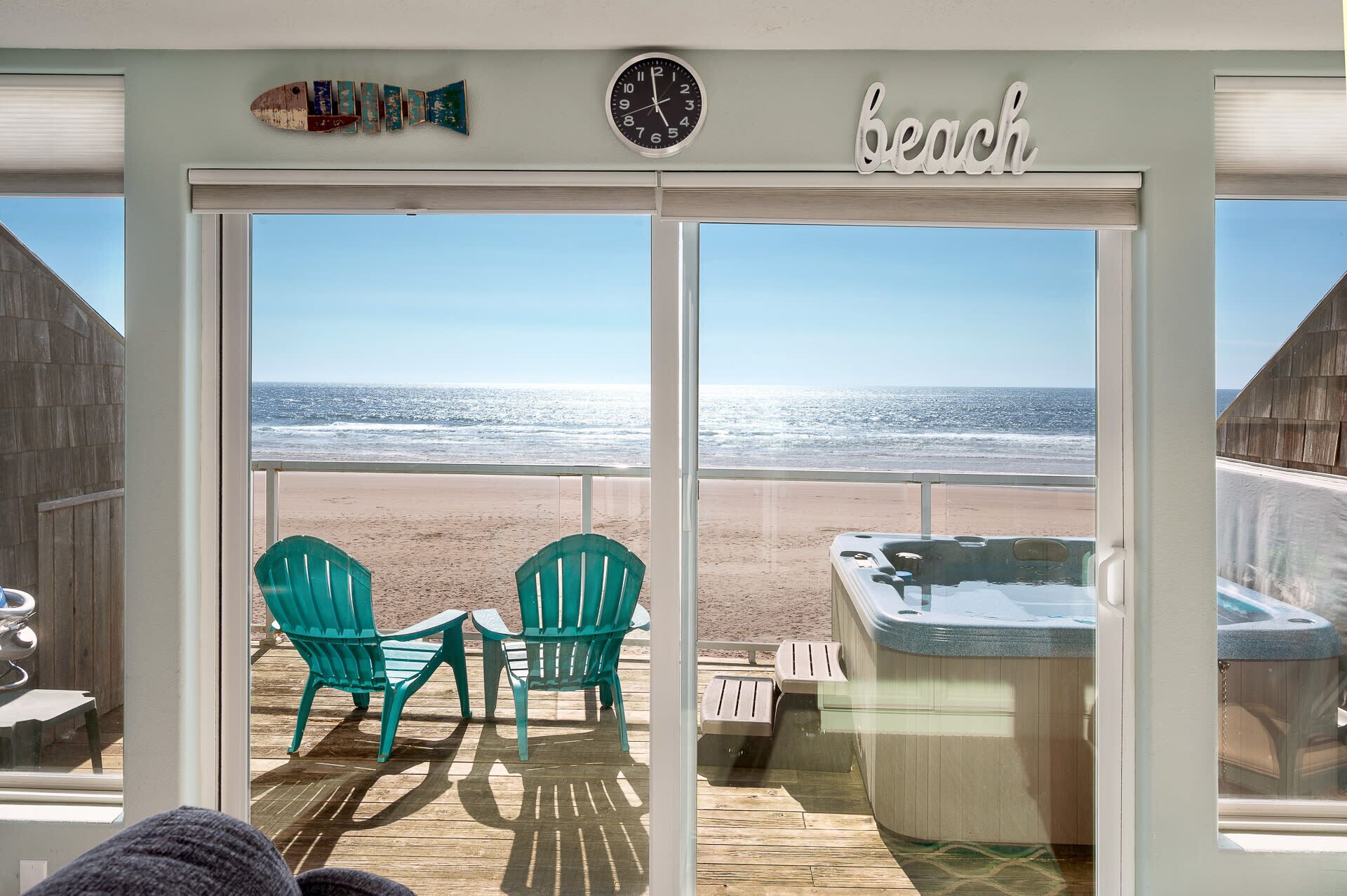 A beach view from a room with a large window, a clock, and a sign that reads "beach".