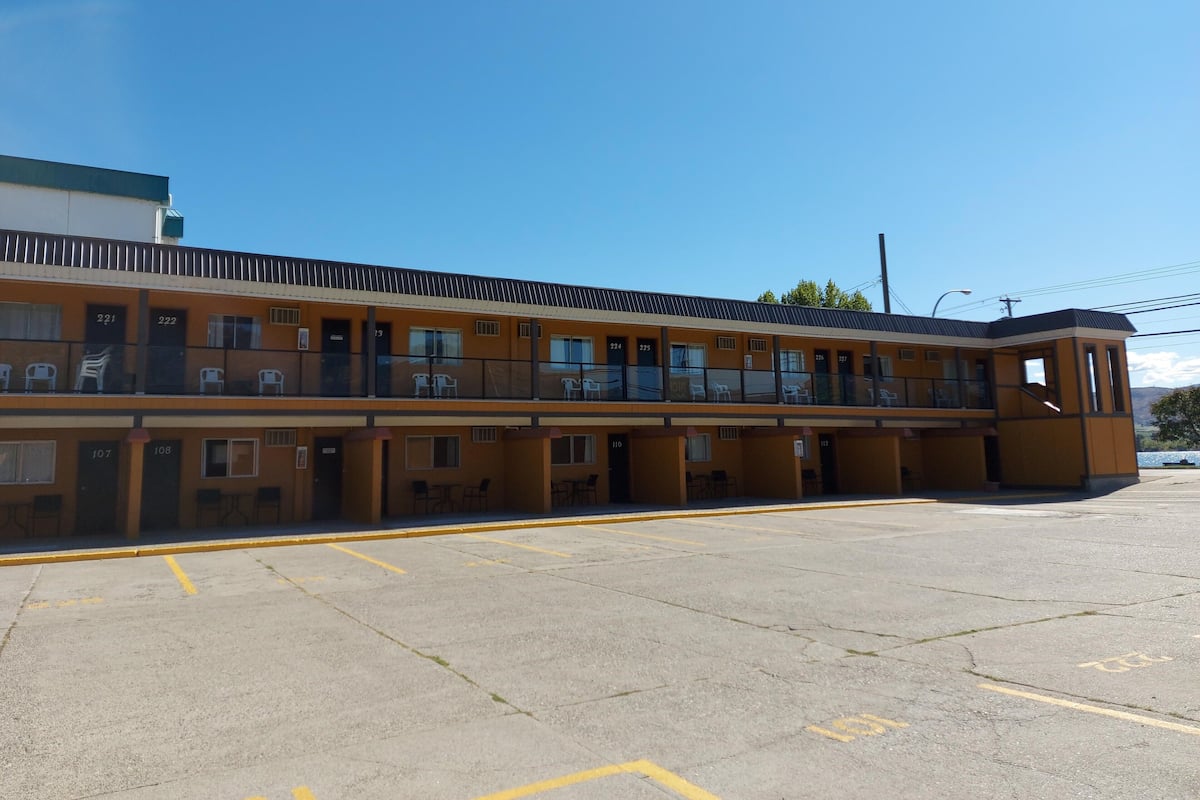 A motel with multiple rooms, each with a door number and a small balcony.