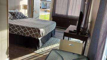A compact hotel room with a bed, a small table, and a chair.