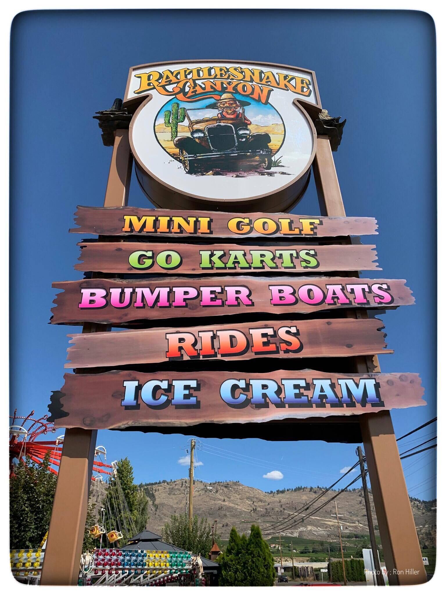Schild für Rattlesnake Canyon mit Annehmlichkeiten wie Minigolf, Go-Karts, Stoßboote, Fahrgeschäften und Eis.