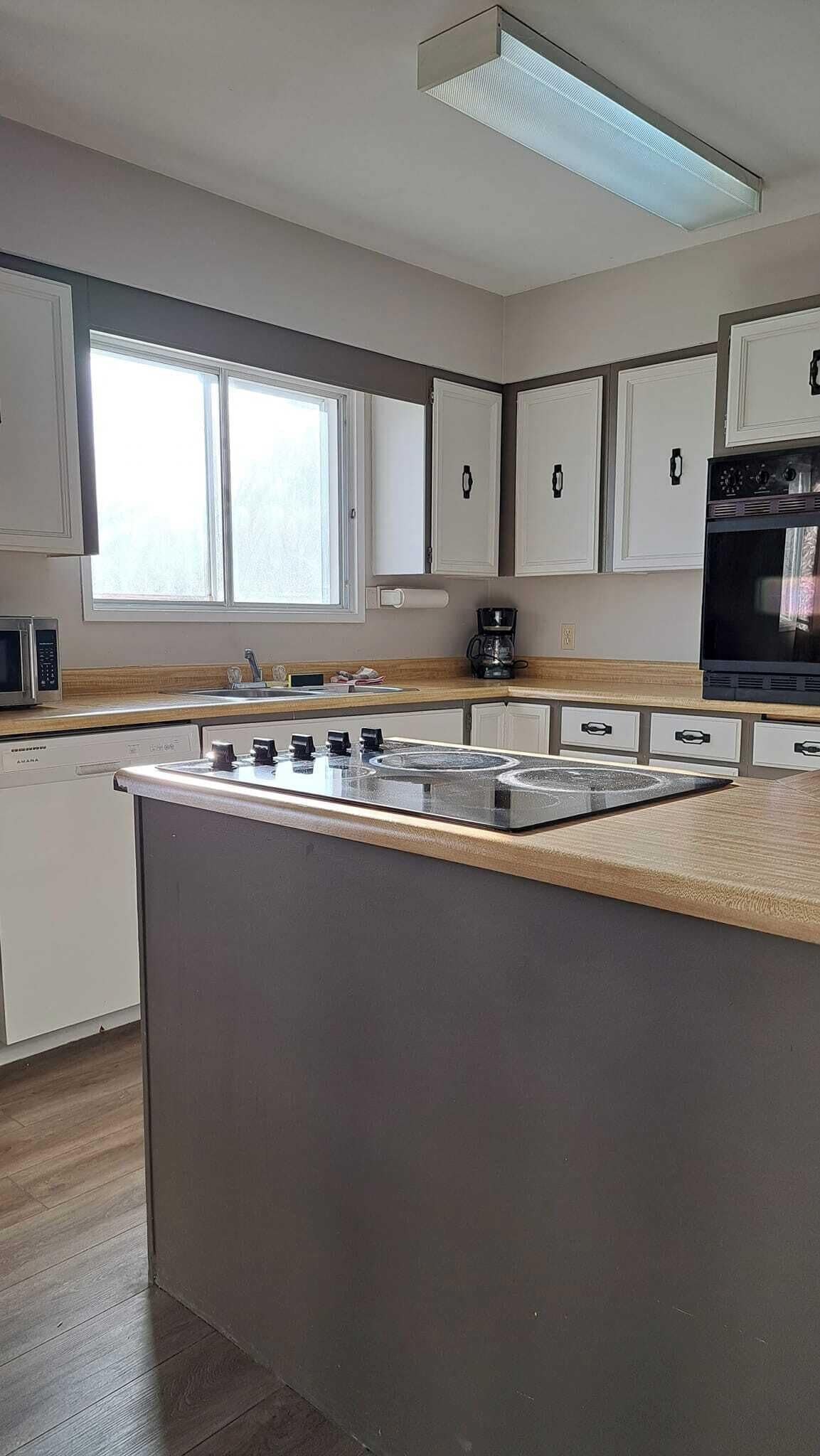 A modern kitchen with a central island, built-in appliances, and ample natural light.