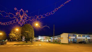 Un motel con una estructura de dos pisos, un estacionamiento y una intersección de calle.